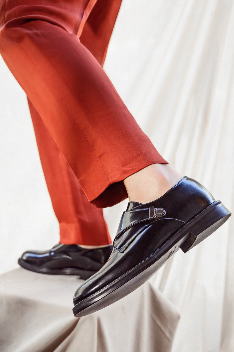 Woman legs in orange trousers in CWEN Black glossed leather monk shoes