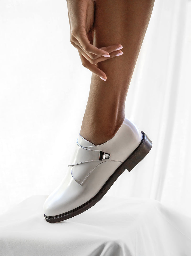 Off white glossed leather CWEN monk shoe on woman foot, off white colour calf lining, leather sole, side view